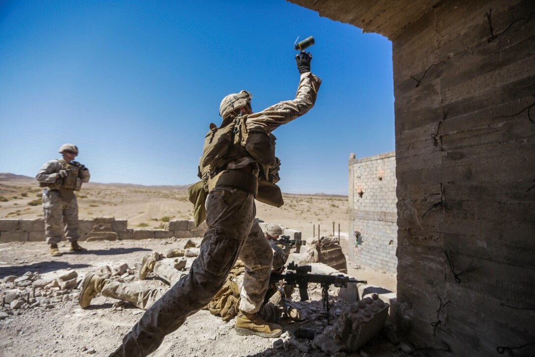 U.S. 5TH FLEET AREA OF OPERATIONS (Sept. 30, 2015)   U.S. Marine Lance Cpl. Aaron Brown throws a smoke grenade during a military operations in urban terrain exercise.  Brown is a rifleman with India Company, Battalion Landing Team 3rd Battalion, 1st Marine Regiment, 15th Marine Expeditionary Unit.  The 15th MEU, embarked aboard the ships of the Essex Amphibious Ready Group, is a forward-deployed, flexible sea-based Marine air-ground task force capable of engaging with regional partners and maintaining regional security.  (U.S. Marine Corps photo by Sgt. Jamean Berry/Released)