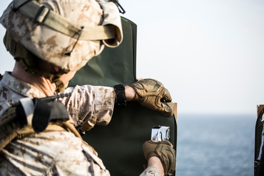 ARABIAN GULF (Oct. 7, 2015) A U.S. Marine with India Battery, Battalion Landing Team 3rd Battalion, 1st Marine Regiment, 15th Marine Expeditionary Unit, repairs a target during a deck shoot aboard the amphibious assault ship USS Essex (LHD 2). The Marines practiced different pivoting drills as well as shooting on the move in order to enhance their marksmanship skills. The 15th MEU, embarked aboard the ships of the Essex ARG, is deployed to maintain regional security in the U.S. 5th Fleet area of operations. (U.S. Marine Corps photo by Cpl. Anna Albrecht/Released)