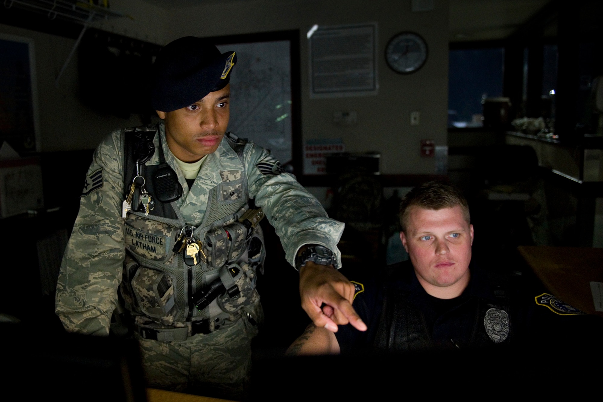 Senior Airman Colin Latham , 434th Security Forces Squadron fire team member,  and  Derek White, 434th Security Forces Squadron Department of the Air Force civilian police officer, monitor surveillance screens at Grissom Air Reserve Base, Ind., Sept. 29, 2015. Grissom is one of only five Air Reserve Command bases in the nation, and the 434th SFS staff work around-the-clock to ensure the mission continues by providing base security and police services. (U.S. Air Force Photo/Tech. Sgt. Benjamin Mota)