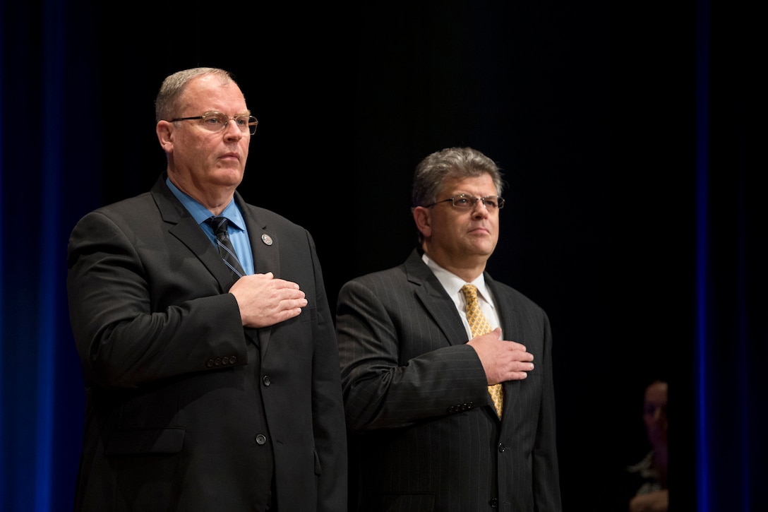 Deputy Defense Secretary Bob Work, left, and Michael L. Rhodes, the Defense Department's director of administration and management, render honors as a soldier sings the national anthem during the Defense Department's civilian awards ceremony at the Pentagon, Oct. 8, 2015. DoD photo by U.S. Air Force Senior Master Sgt. Adrian Cadiz