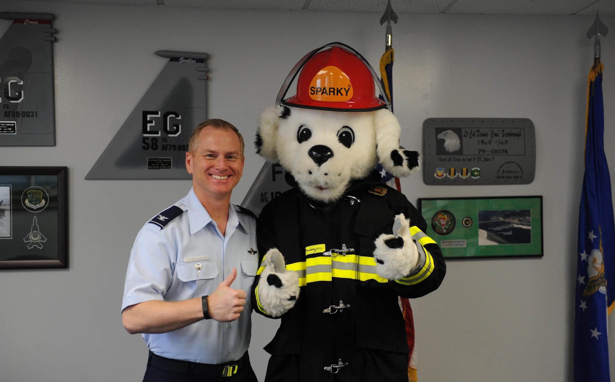 Col. Dennis Scarborough, 81st Training Wing vice commander, poses for a photo with Sparky the Fire Dog as Keesler firefighters visit the 81st TRW headquarters building to kick off Fire Prevention Week, Oct. 5, 2015, Keesler Air Force, Miss. The week-long event includes fire drills, literature hand-outs and stove fire demonstrations around the base and concludes with an open house at the fire department Oct. 10. (U.S. Air Force photo by Kemberly Groue)