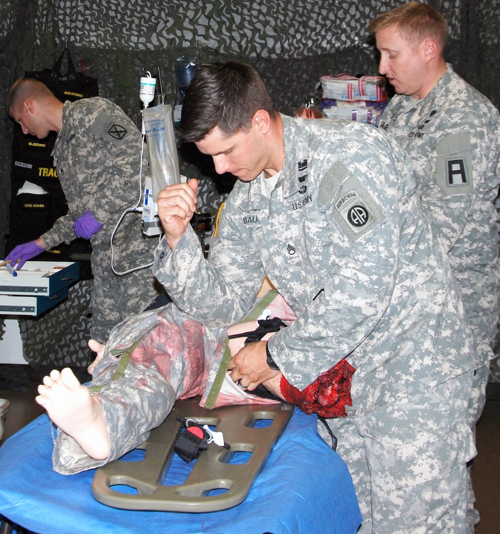 Staff Sgt. Michael Baugher (foreground) applies direct pressure while applying a tourniquet to a mannequin during the pilot course for becoming a national registered paramedic held at the U.S. Army Medical Department Center and School, U.S. Army Health Readiness Center of Excellence at Fort Sam Houston Sept. 14-25.