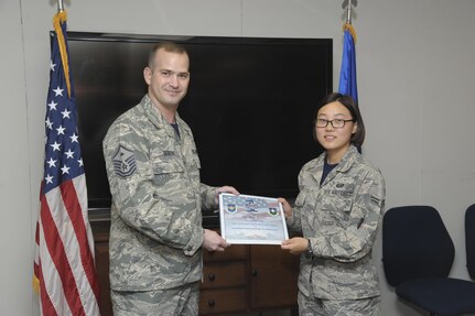 Master Sgt. Chris Booth (left), 802nd Force Support Squadron first sergeant, presents Airman First Class Yan Chi with the Diamond Sharp Award Oct. 2 at Joint Base San Antonio-Randolph. The Diamond Sharp Award recognizes Airmen who have actively demonstrated their commitment to Air Force values or have gone above and beyond in helping others.