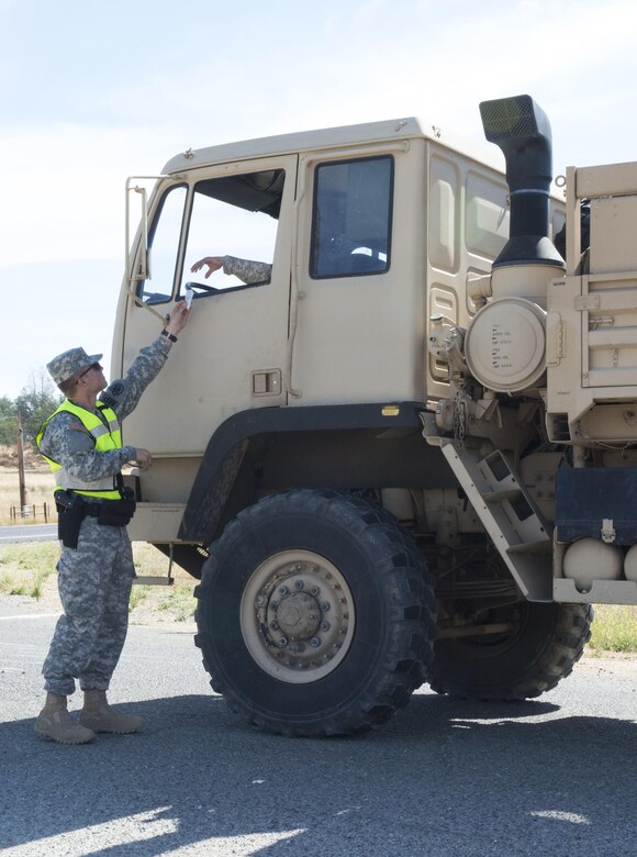 U.S. Army Pfc. Dalton Potts, a military police officer with the 382nd Military Police Detachment from San Diego, checks identification cards at an entry control point at Fort Hunter Liggett, Calif., Aug. 3. Potts, a Corona, Calif., native, worked with Fort Hunter Liggett police to maintain law and order and force protection during his annual training, July 26 - Aug. 10. The 382nd supported WAREX 91-15, “Operation Caucasus Restore.” WAREX 91-15 prepares Reserve and National Guard units with real world and scenario based training, as well as basic Soldier skills during the exercise. (Photo by U.S. Army Staff Sgt. Nazly Confesor, 200th MP Command Public Affairs/Released)