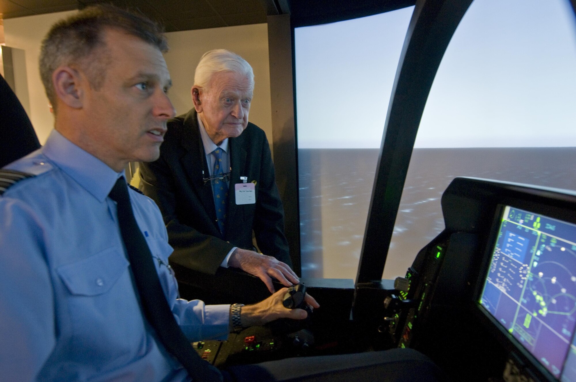 British Capt. Peter “Willy” Hatchett, attached to the F-35 Joint Strike Fighter Program, uses an F-35 simulator to show Tom "Ginger" Neil, a renowned World War II flying ace, the capabilities of the aircraft inside the Lockheed Martin office in Arlington, Va., on Oct. 7, 2015. (U.S. Air Force photo/Sean Kimmons)