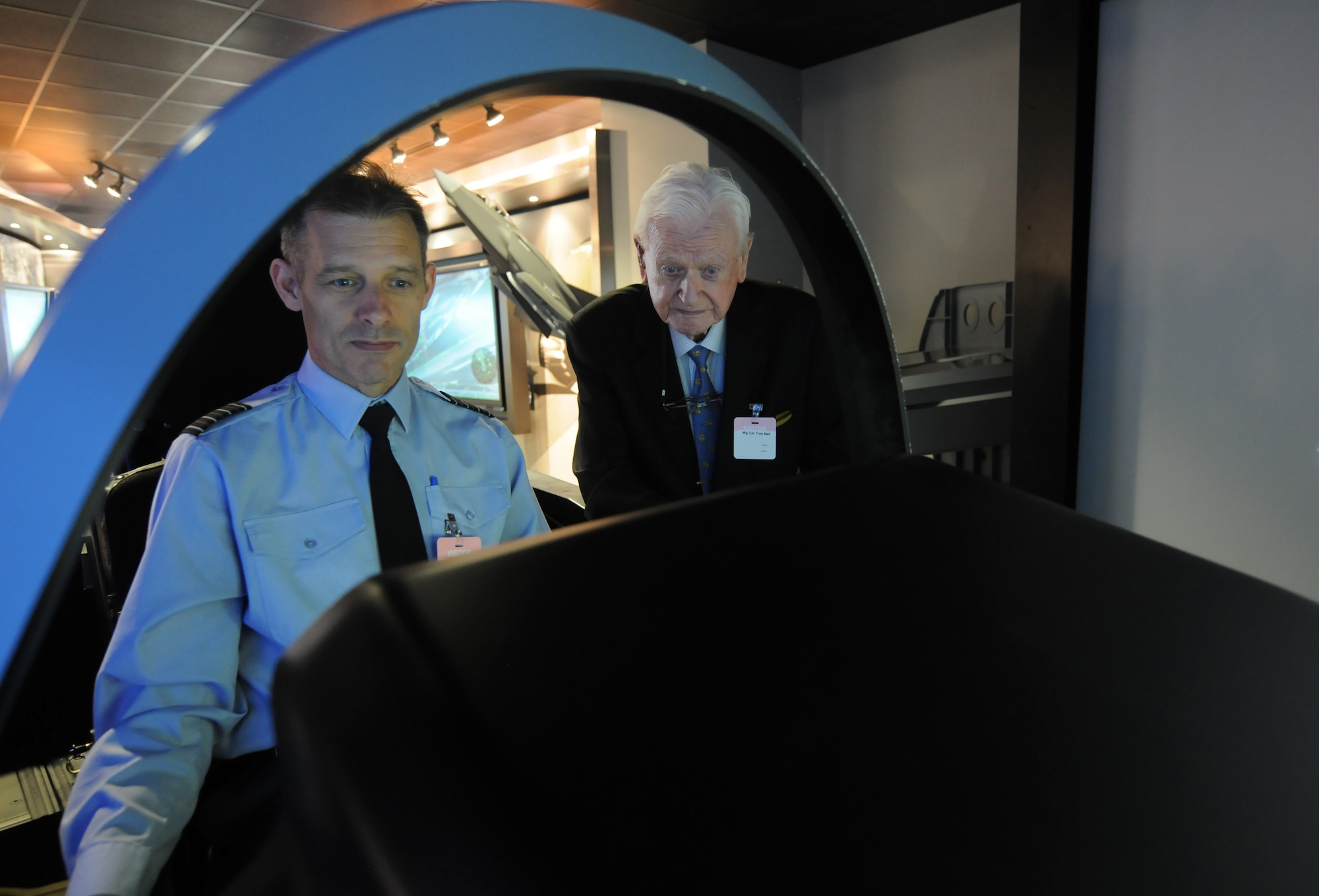 British Capt. Peter “Willy” Hatchett, attached to the F-35 Joint Strike Fighter Program, uses an F-35 simulator to show Tom "Ginger" Neil, a renowned World War II flying ace, the capabilities of the aircraft inside the Lockheed Martin office in Arlington, Va., on Oct. 7, 2015. (U.S. Air Force photo/Sean Kimmons)