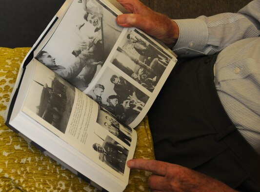 Tom "Ginger" Neil, a renowned World War II flying ace, talks about past missions as he looks through old photos of him during World War II on Oct. 7, 2015. (U.S. Air Force photo/Sean Kimmons)