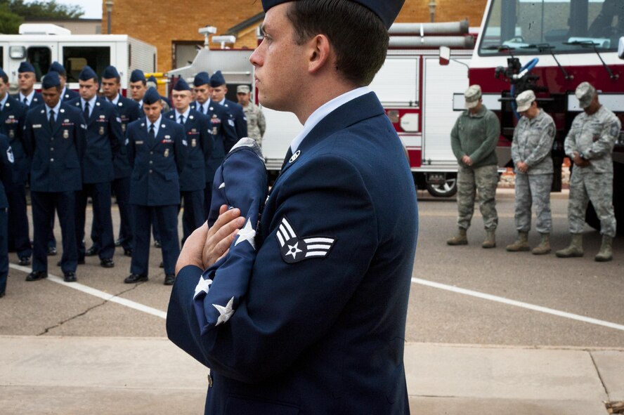 Cannon firefighters assigned to the 27th Special Operations Civil Engineering Squadron, prepare for the raising of the flag to half-staff during a ceremony dedicated to the fallen firefighters, Oct. 04, 2015 at Cannon Air Force Base, N.M. The ceremony was in observance of Bells Across America, a day dedicated to paying tribute to fellow firefighters who gave their life in the service of others. (U.S. Air Force photo/Tech. Sgt. Manuel J. Martinez)