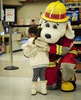 Sparky the Fire Dog, National Fire Prevention Association spokesdog, hugs a girl during a visit to the Base Commissary and Exchange during Fire Prevention Week on Hurlburt Field, Fla., Oct. 4, 2015. Sparky the Fire Dog and Airmen with the Hurlburt Field Fire Department greet Airmen on base, visited Child Development Centers, the base library and other locations around base throughout the week to educate and raise awareness about fire prevention. This year’s theme is “Hear the BEEP, where you SLEEP: Every Bedroom Needs A Working Smoke Alarm!” Fire Prevention Week will conclude with a fire muster challenge open to Airmen around base, Oct. 9. (U.S. Air Force photo by Senior Airman Meagan Schutter)