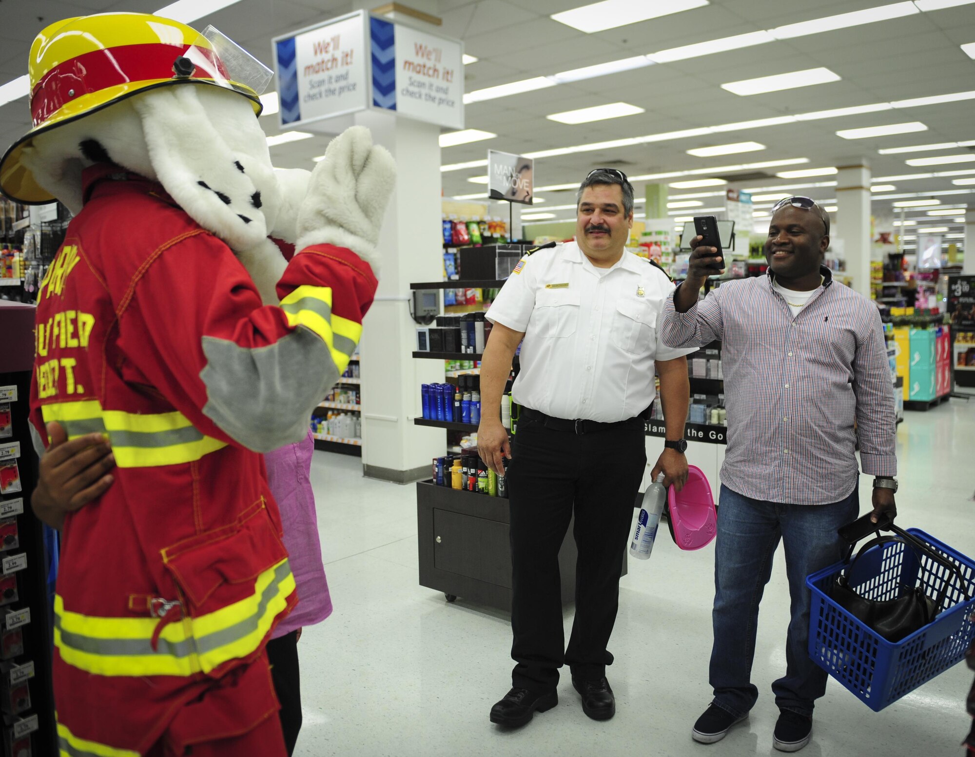 Shoppers at the Base Exchange take a photo with Sparky the Fire Dog, National Fire Prevention Association spokesdog, during Fire Prevention Week on Hurlburt Field, Fla., Oct. 4, 2015. Sparky the Fire Dog and Airmen with the Hurlburt Field Fire Department greet Airmen on base, visited Child Development Centers, the base library and other locations around base throughout the week to educate and raise awareness about fire prevention. This year’s theme is “Hear the BEEP, where you SLEEP: Every Bedroom Needs A Working Smoke Alarm!” Fire Prevention Week will conclude with a fire muster challenge open to Airmen around base, Oct. 9. (U.S. Air Force photo by Senior Airman Meagan Schutter)