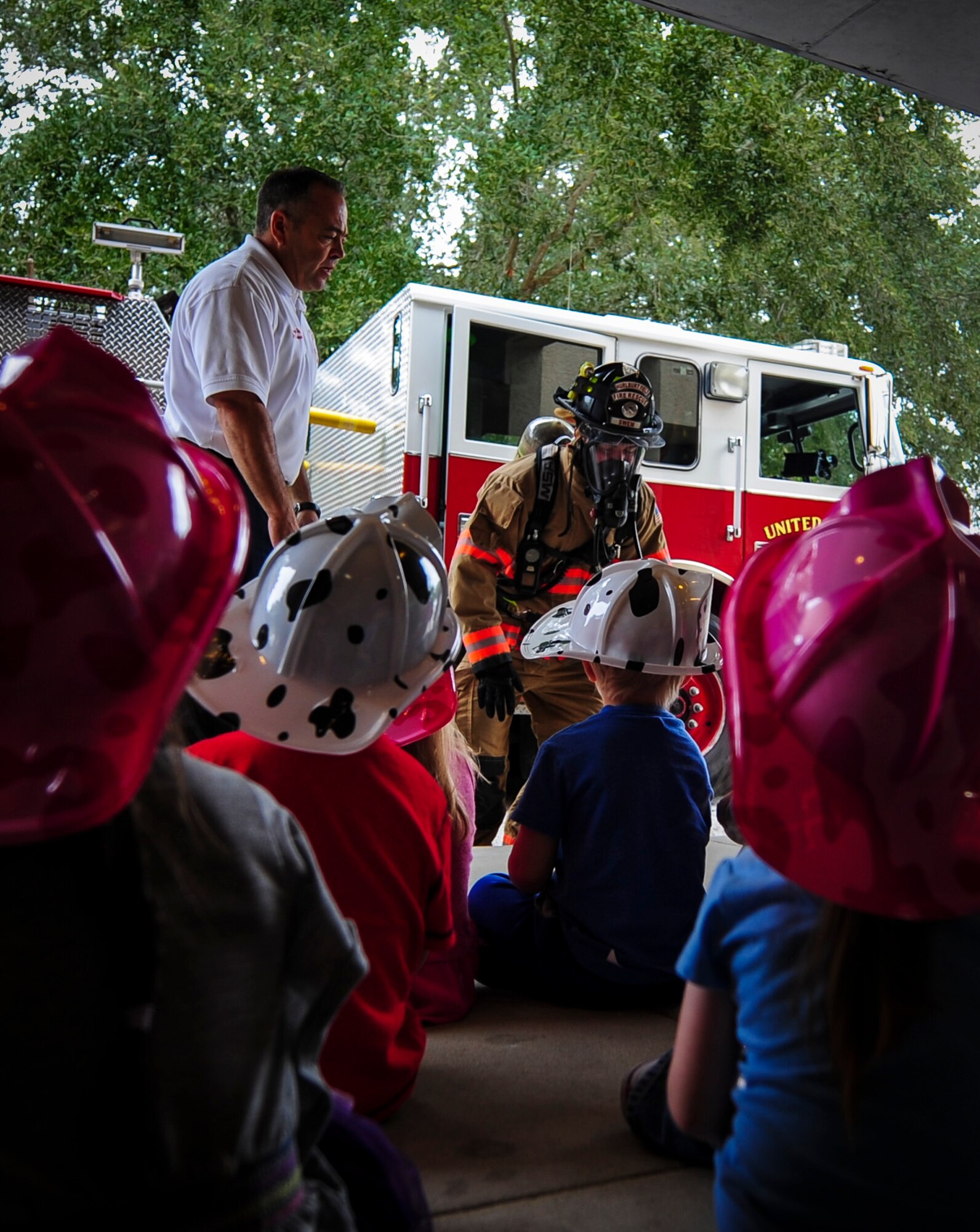 Airman 1st Class Chaz Swem, 1st Special Operations Civil Engineer Squadron firefighter, demonstrates to children how firefighters look with all of their gear on when responding to a fire during a Fire Prevention Week visit at the Child Development Center Main on Hurlburt Field, Fla., Oct. 6, 2015. Sparky the Fire Dog and Airmen with the Hurlburt Field Fire Department greet Airmen on base, visited Child Development Centers, the base library and other locations around base throughout the week to educate and raise awareness about fire prevention. This year’s theme is “Hear the BEEP, where you SLEEP: Every Bedroom Needs A Working Smoke Alarm!” Fire Prevention Week will conclude with a fire muster challenge open to Airmen around base, Oct. 9. (U.S. Air Force photo by Senior Airman Meagan Schutter)