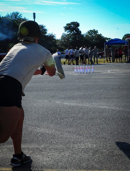 An Airman with the 1st Special Operations Civil Engineer Squadron tosses a fire hose at bowling pins during Fire Prevention Week’s fire muster challenge on Hurlburt Field, Fla., Oct. 8, 2015. Sparky the Fire Dog, National Fire Prevention Association spokesdog, and Airmen with the Hurlburt Field Fire Department welcomed Airmen on base, visited Child Development Centers, the base library and other locations around base throughout the week to educate and raise awareness about fire prevention. This year’s theme is “Hear the BEEP, where you SLEEP: Every Bedroom Needs A Working Smoke Alarm!” Fire Prevention Week concluded with a fire muster challenge that was open to Hurlburt Airmen. (U.S. Air Force photo by Senior Airman Meagan Schutter)