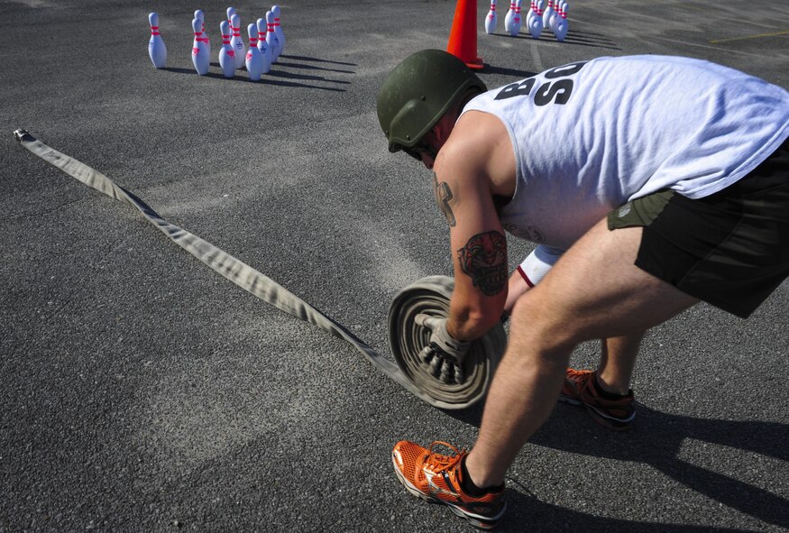 Airman 1st Class John Nipp, 1st Special Operations Squadron explosive ordnance disposal apprentice, rolls a fire hose during Fire Prevention Week’s fire muster challenge on Hurlburt Field, Fla., Oct. 8, 2015. Sparky the Fire Dog, National Fire Prevention Association spokesdog, and Airmen with the Hurlburt Field Fire Department welcomed Airmen on base, visited Child Development Centers, the base library and other locations around base throughout the week to educate and raise awareness about fire prevention. This year’s theme is “Hear the BEEP, where you SLEEP: Every Bedroom Needs A Working Smoke Alarm!” Fire Prevention Week concluded with a fire muster challenge that was open to Hurlburt Airmen. (U.S. Air Force photo by Senior Airman Meagan Schutter)