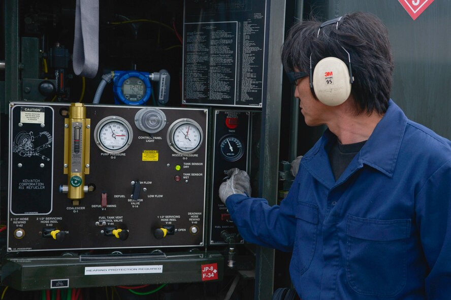 Hiroyuki Sekimoto, 374th Logistics Readiness Squadron fuels management flight aircraft refueling vehicle operator, issues fuel to a C-130 Hercules at Yokota Air Base, Japan, Oct. 1, 2015. While providing fuel to the aircraft, Sekimoto is also monitoring the nozzle pressure to ensure no leaks or spills occur due to excess pressure on the issue hose. (U.S. Air Force photo by Senior Airman David Owsianka/Released)