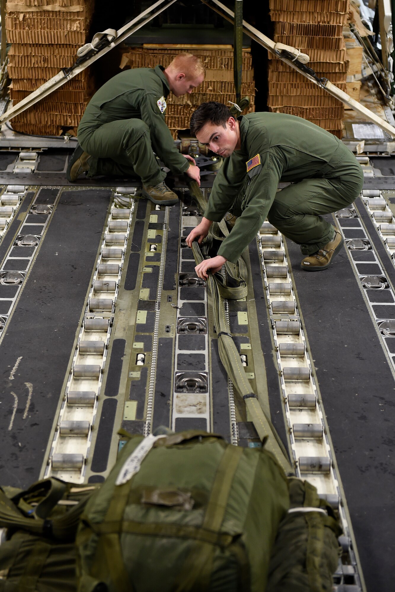 Senior Airman Josh Beeler (right) and Senior Airman Cody Sellers, 8th Airlift Squadron C-17 Globemaster III loadmasters, load cargo onto a C-17 Sept. 27, 2015 at Pope Army Airfield, N.C. The cargo was part of the more than 50,000 pounds of cargo and more than 500 paratroopers delivered via air-land operations in White Sands, N.M., as part of an Emergency Deployment Readiness Exercise. (U.S. Air Force photo/Staff Sgt. Tim Chacon)