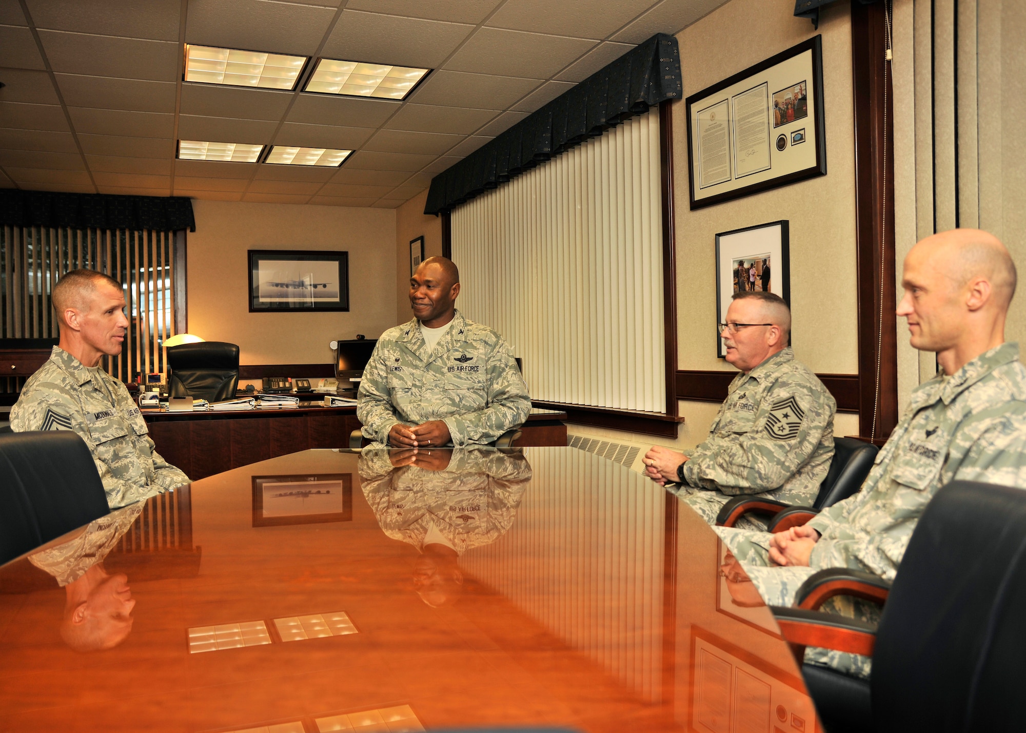 (Left) Command Chief Master Sgt. Steven McDonald, 1st Fighter Wing air combat command chief, talks with Col. Rodney Lewis, 319th Air Base Wing commander, Command Chief Master Sgt. David Duncan, 319th ABW command chief and Col. Robert Cook, 319th ABW vice commander, about the importance of Air Mobility Command and Air Combat Command working together regarding the unmanned aircraft mission Oct. 7, 2015, on Grand Forks Air Force Base, North Dakota. Chief McDonald visited the 69th Reconnaissance Group, 69th Maintenance Squadron and the 348th Reconnaissance Squadron to understand more about their mission and thank Airmen for their hard work. (U.S. Air Force photo by Senior Airman Xavier Navarro/Released) 