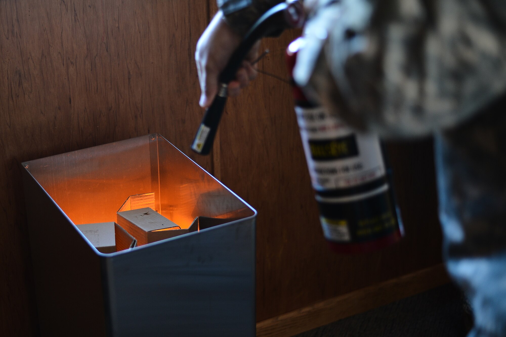 A Team Buckley member puts out a simulated trashcan fire as part of fire extinguisher training Oct. 8, 2015, on Buckley Air Force Base, Colo. The Buckley Fire Department offered the training, which involved pointing a fake fire extinguisher at simulated house fires, to Team Buckley members as part of Fire Prevention Week. (U.S. Air Force photo by Staff Sgt. Darren Scott/Released)