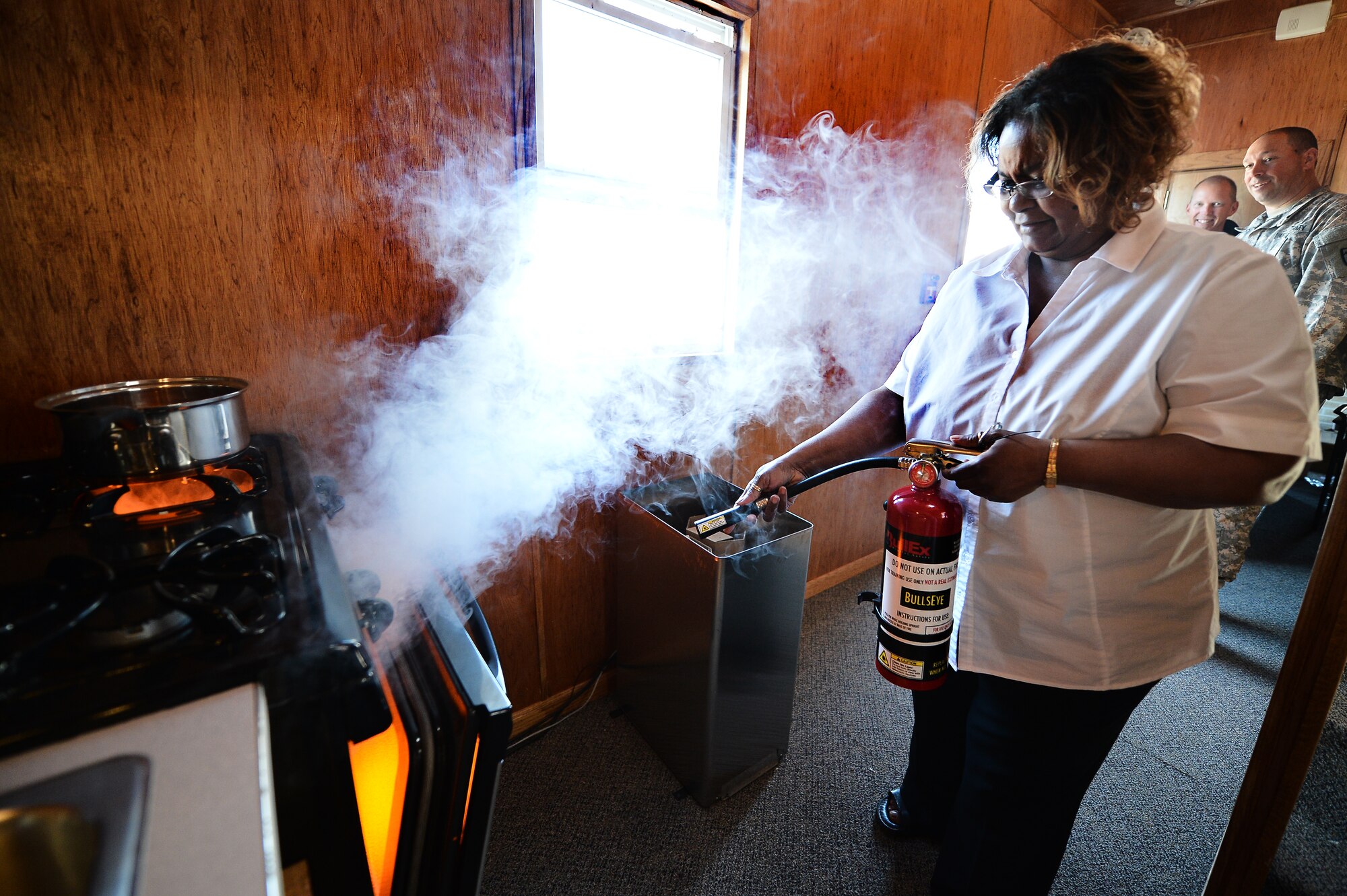 Olympia Osborne, 460th Civil Engineer Squadron, puts out a simulated oven fire as part of fire extinguisher training Oct. 8, 2015, on Buckley Air Force Base, Colo. The Buckley Fire Department offered the training, which involved pointing a fake fire extinguisher at simulated house fires, to Team Buckley members as part of Fire Prevention Week. (U.S. Air Force photo by Staff Sgt. Darren Scott/Released)