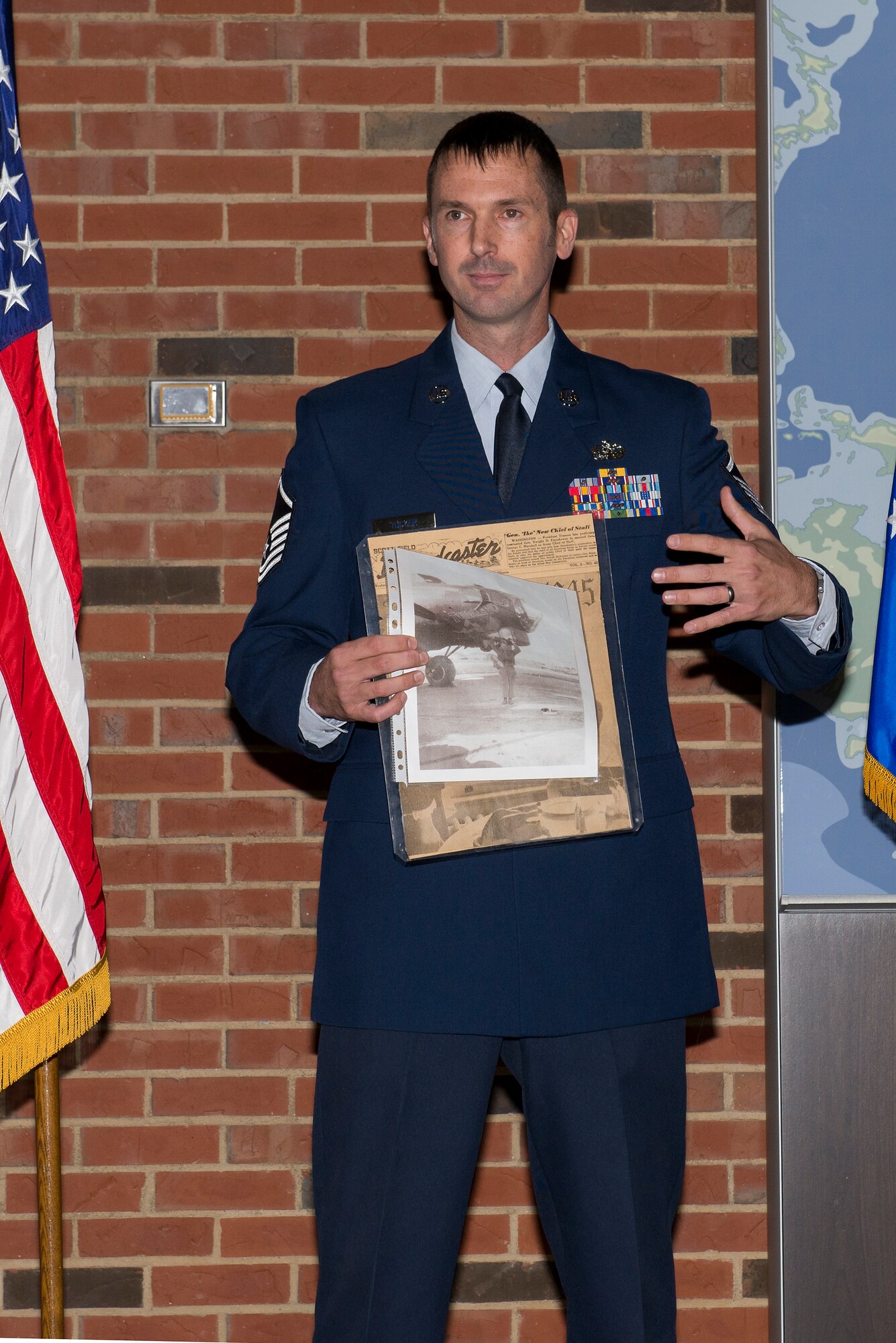 Master Sgt. Michael Tucker, Cyber Space Support Squadron NCOIC of Cyber Operation Requirements, shows a copy of the Scott Broadcaster that his grandfather was on the cover of in 1945. Michael Tucker’s grandfather was at Scott Field during the end of his service in World War 2. (U.S. Air Force Photo by Senior Airman Megan Friedl)