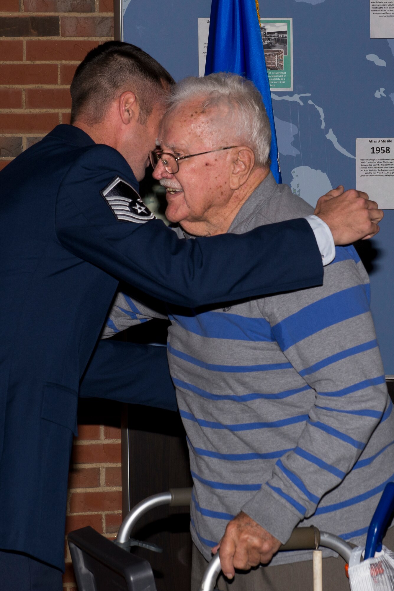 Master Sgt. Michael Tucker, Cyber Space Support Squadron NCOIC of Cyber Operation Requirements, hugs his grandfather, Robert Tucker Sr. right after he received his Master Sgt. stripes. Michael Tucker’s grandfather was very influential to him in his life and career. (U.S. Air Force Photo by Senior Airman Megan Friedl)