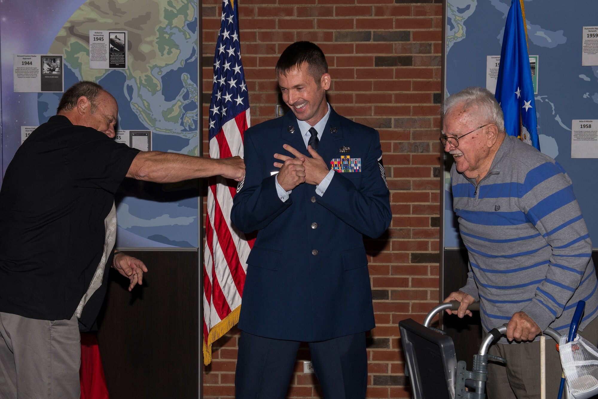 Master Sgt. Michael Tucker, Cyber Space Support Squadron NCOIC of Cyber Operation Requirements, has his Master Sgt. stripes tacked on by his father, Robert Tucker II and his grandfather, Robert Tucker Sr. Michael Tucker attributes both his father and grandfather for many of his successes in his career. (U.S. Air Force Photo by Senior Airman Megan Friedl)
