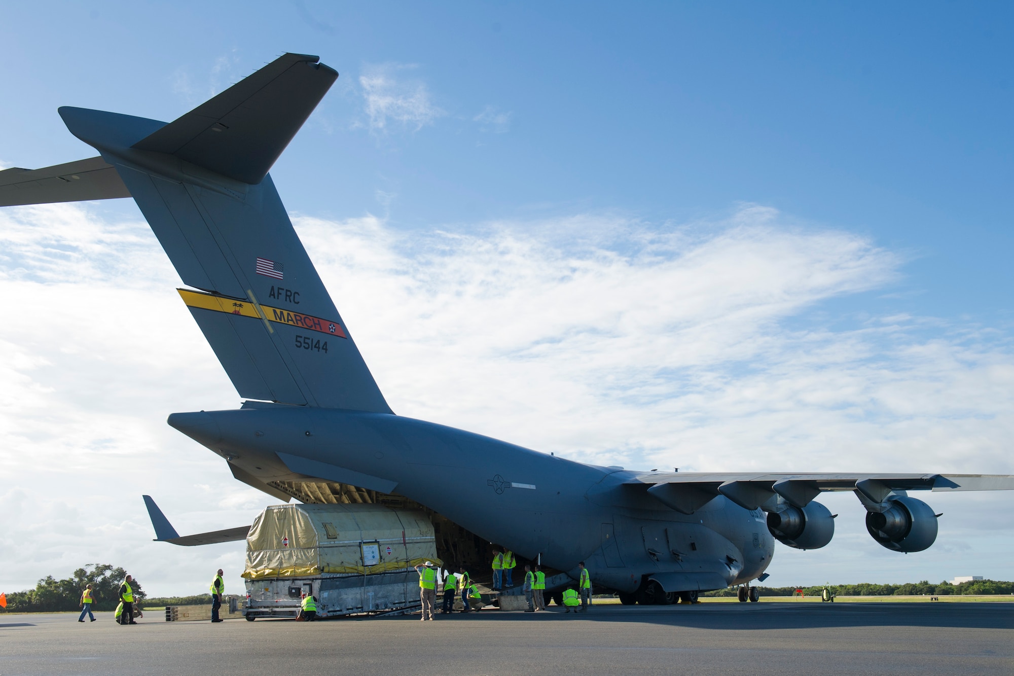 A quality assurance team from the 45th Launch Group receives an Air Force GPS IIF -12 satellite from an Air Force C-17 Globemaster III from March Air Reserve Base, Calif.,  that delivered the last model of the IIF series to Cape Canaveral Air Force Station Oct. 8, 2015. A crowd from the government and industry partnership, who will complete the satellite’s final assembly, gathered on the Cape’s “Skid Strip” to watch the off-loading of the satellite they will prepare to launch aboard a United Launch Alliance rocket in 2016. (U.S. Air Force photo/James Rainier)