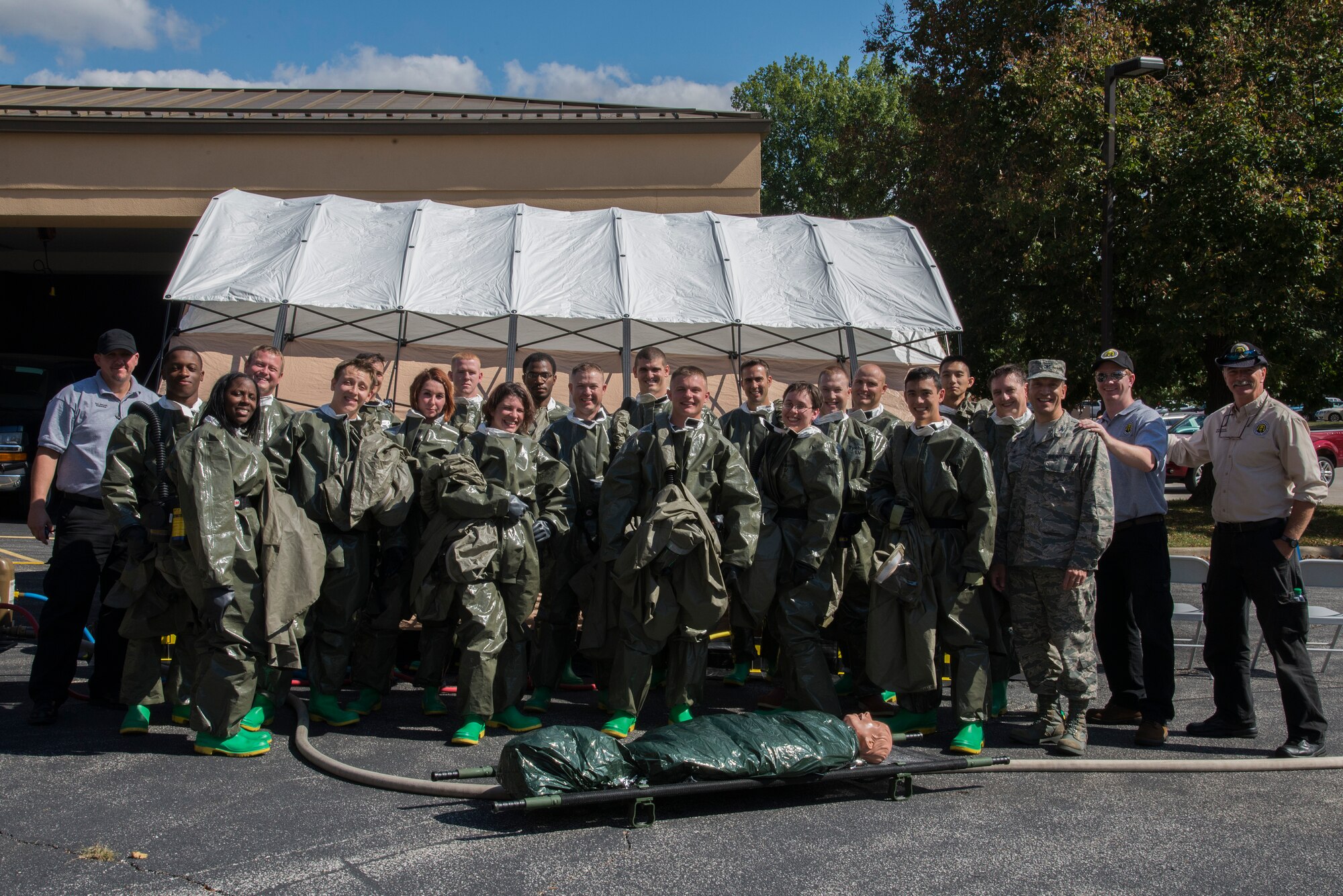 Medical group members pose for a group photo after completing a timed test on their effectiveness, at Scott Air Force Base Medical Clinic, October 1, 2015. The member participating were expected to take care of two patients and set up the decontamination tent with a goal of 20 minutes. (U.S. Air Force photo by Airman Gwendalyn Smith)