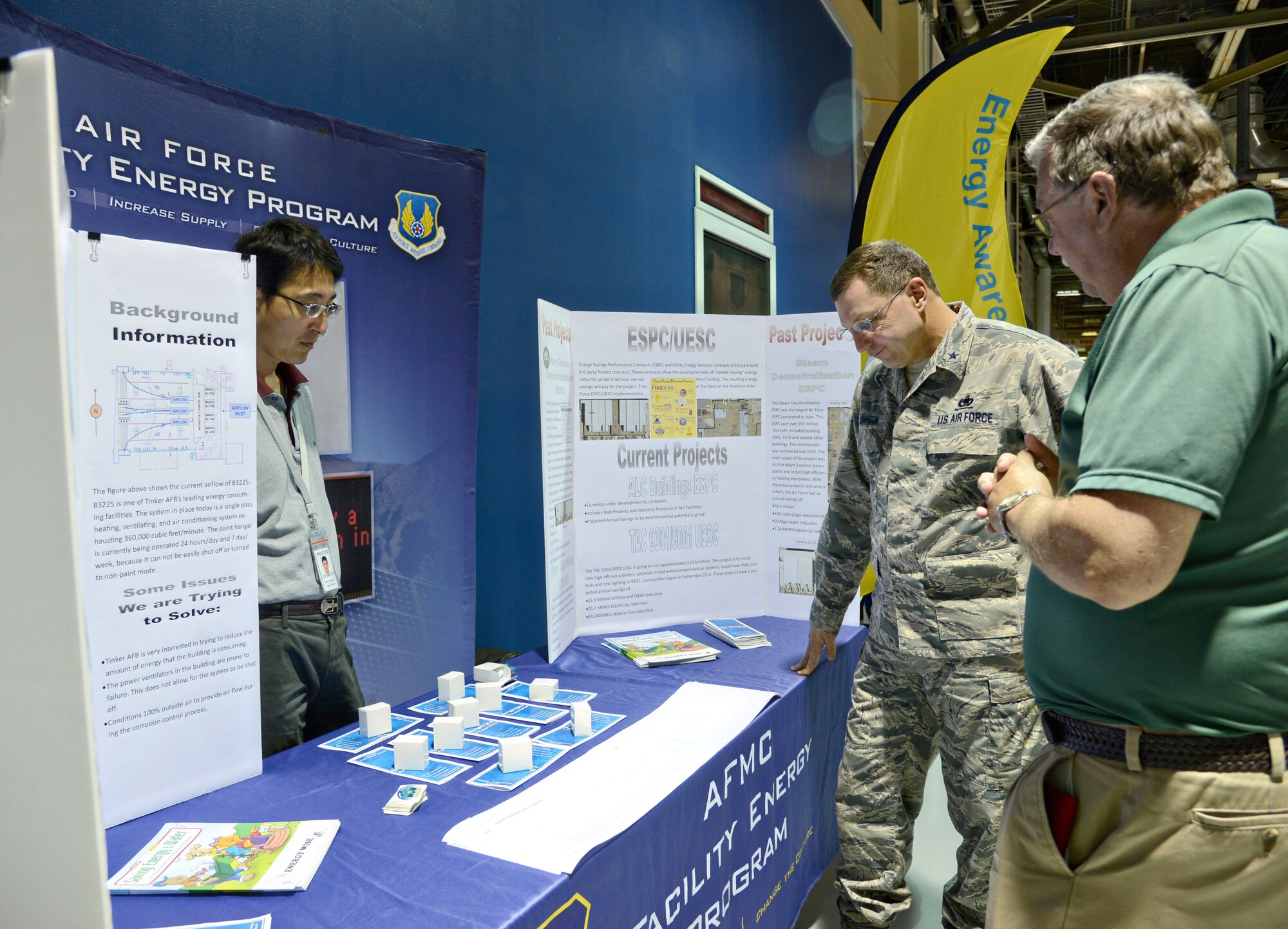 Ik-Seong Joo, a resource efficiency manager with the 72nd Air Base Wing Civil Engineer Directorate, left, and Carmie Ashley, 72nd ABW/CE chief of portfolio optimization, talk with Oklahoma City Air Logistics Complex Commander Brig. Gen. Mark Johnson Oct. 2 during an Energy Awareness Month expo in Bldg. 3001. (Air Force photo by Kelly White/Released)

