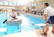 Staff Sgt. Austin Goldstein, with the 552nd Air Control Network Squadron, gets encouragement from his teammate during a cardboard regatta held at the Rose State pool Oct. 2. The regatta, put on by the 552nd Maintenance Squadron’s Top Three, had four teams competing to complete as many laps in their boats in the Rose State pool as possible in the time allowed. The 552nd Air Control Wing’s other Comprehensive Airman Fitness day events included a shooting competition, archery, fishing, and a golf tournament. (Air Force photo by Kelly White/Released)
