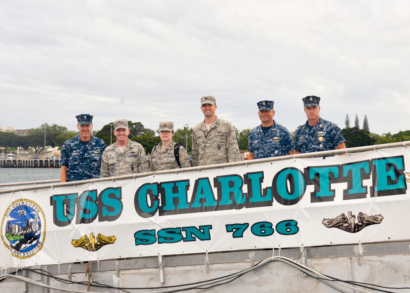U.S. Air Force Capt. Patrick McAfee (center right), U.S. Air Force Lt. Gen. Stephen W. Wilson (second from left), U.S. Strategic Command deputy commander, his executive officer and senior leaders of the USS Charlotte, a fast attack submarine, pose for a photo on the vessel’s brow at Joint Base Pearl Harbor-Hickam, Hawaii, March 4, 2015. McAfee is one of the first four Air Force intercontinental ballistic missile (ICBM) officers selected to serve with U.S. Navy Submarine Forces (SUBFOR) ballistic missile submarine (SSBN) units through the Striker Trident nuclear officer exchange program. In November, he left the 341st Missile Wing at Malmstrom Air Force Base, Mont., to begin a three-year assignment as a strategic targeting assistant in the strategic forces, nuclear weapons and force protection directorate at Commander, Submarine Force, U.S. Pacific Fleet (COMSUBPAC), Joint Base Pearl Harbor-Hickam, Hawaii. The Striker Trident exchange program enables Navy and Air Force nuclear-qualified officers to gain an expanded view of the nuclear triad, as well as each leg’s respective role in U.S. Strategic Command’s (USSTRATCOM) strategic deterrence mission. (U.S. Navy photo by Mass Communication Specialist 1st Class Jason Swink)