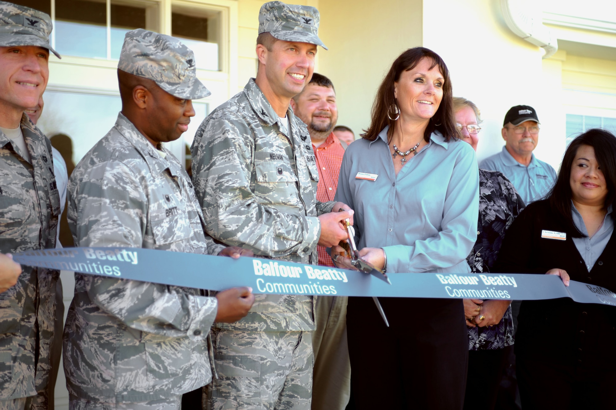 Col. Ty Neuman, 28th Bomb Wing vice commander, center left, and Deana Fulton, Balfour Beatty community manager, center right, celebrate the opening of a new community center with an official ribbon cutting ceremony at Ellsworth Air Force Base, S.D., Oct. 7, 2015. The center will be available for event reservations by base residents and serve as a venue for BBC, the contractor of Ellsworth's privatized base housing. (U.S. Air Force photo by Airman Sadie Colbert/Released)