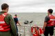 Airmen from Seymour Johnson Air Force Base, North Carolina and a sailor from Coast Guard Station Hobucken, North Carolina, observe Capt. Glen Leavitt, 334th Fighter Squadron weapons systems officer, as he situates himself in the water during a search and rescue training mission, Sept. 24, 2015, off the coast of North Carolina. Seymour Johnson AFB performed a joint search and rescue exercise with the U.S. Coast Guard to give aircrew and first responders hands-on experience with emergency scenarios. (U.S. Air Force photo/Airman Shawna L. Keyes)