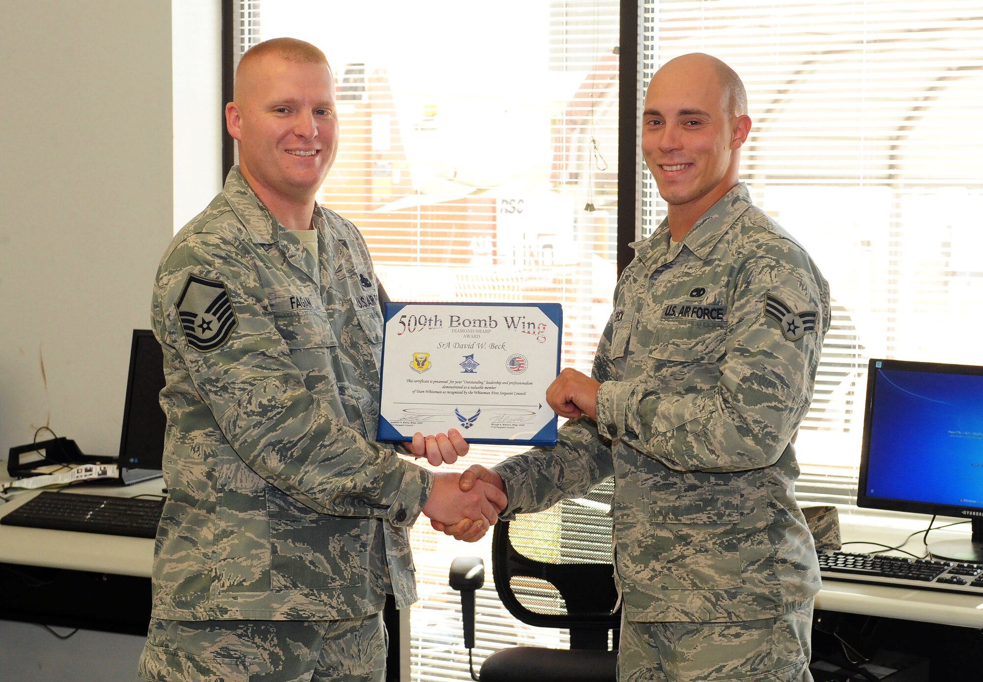 Master Sgt. Steven Fagan, 495th Fighter Group, Detachment 303 interim first sergeant, presents the Diamond Sharp Award to Senior Airman David Beck, 495th FG, Det. 303 integrated avionics journeyman, Sept. 11, 2015, at Whiteman Air Force Base, Mo. Beck organized the Philip Macri Golf Tournament which raised $10,000 for local disabled students, coached two little league baseball teams, and earned a 3.4 GPA on a class toward his bachelor's degree in biology. (U.S. Air Force photo by Airman 1st Class Jazmin Smith/Released)