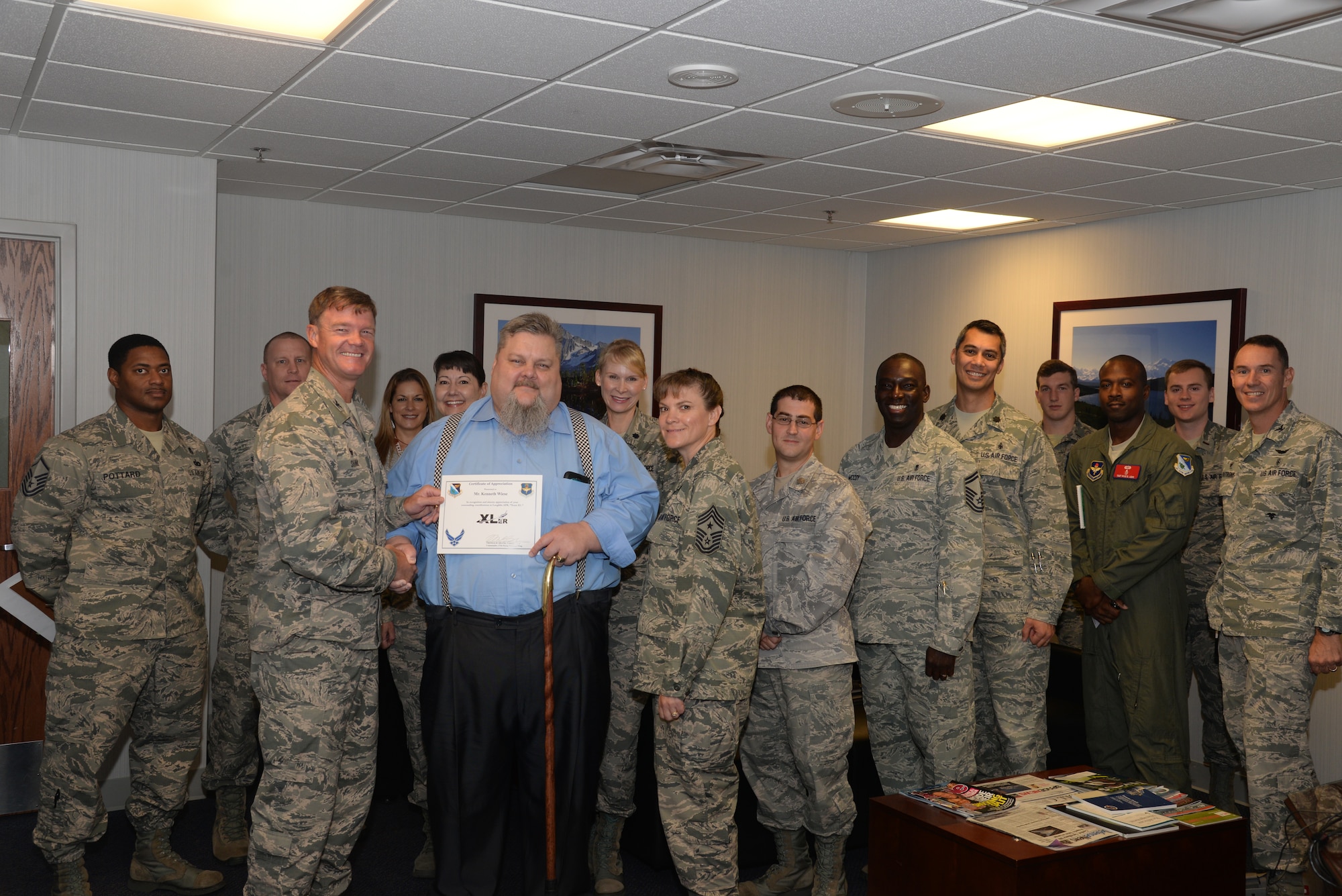 Kenneth Wiese, center, 47th Medical Group quality,risk and credentialing manager, poses with Col. Thomas Shank, 47th Flying Training Wing commander, Chief Master Sgt. Teresa Clapper, 47th FTW command chief, after accepting the “XLer of the Week” award, here, Oct. 6, 2015. The “XLer” is a weekly award chosen by wing leadership and is presented to those who consistently make outstanding contributions to their unit and Laughlin. (U.S. Air Force photo by Airman 1st Class Brandon May) (Released)