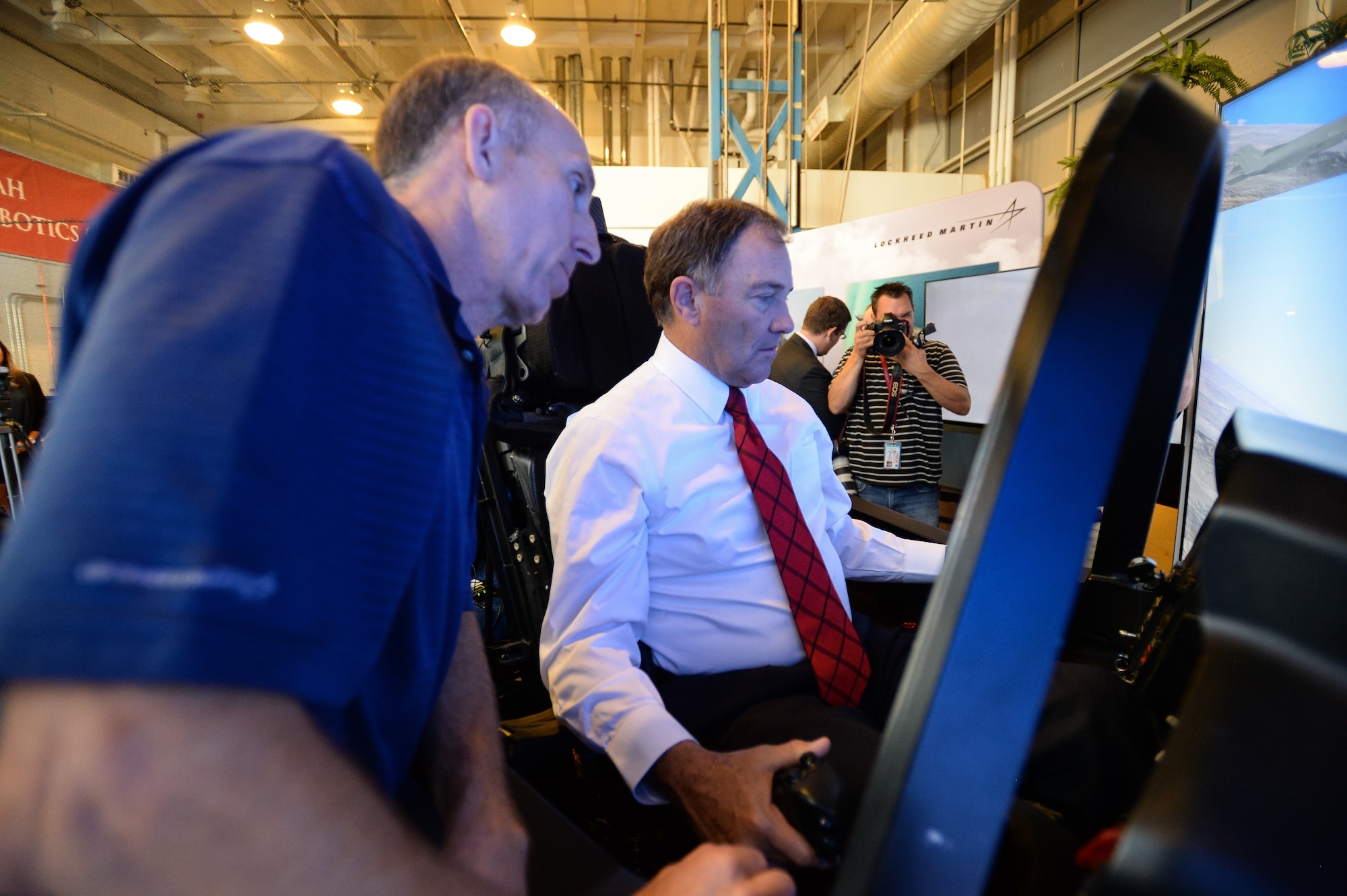 Utah Gov. Gary Herbert flies a simulated F-35 Lightning II aircraft with the assistance of cockpit demonstrator pilot Eric Best, at the University of Utah campus, Salt Lake City, Utah, Wednesday, Oct. 7, 2015. The combined efforts of Hill Air Force Base and Lockheed Martin brought the interactive cockpit demonstrator to the university, allowing civic leaders and citizens a unique opportunity to experience and learn about the Air Force's newest and most advanced fighter. Hill Air Force Base's 388th and 419th Fighter Wings are the first in the Air Force to fly combat-coded F-35s. (U.S. Air Force photo by R. Nial Bradshaw)