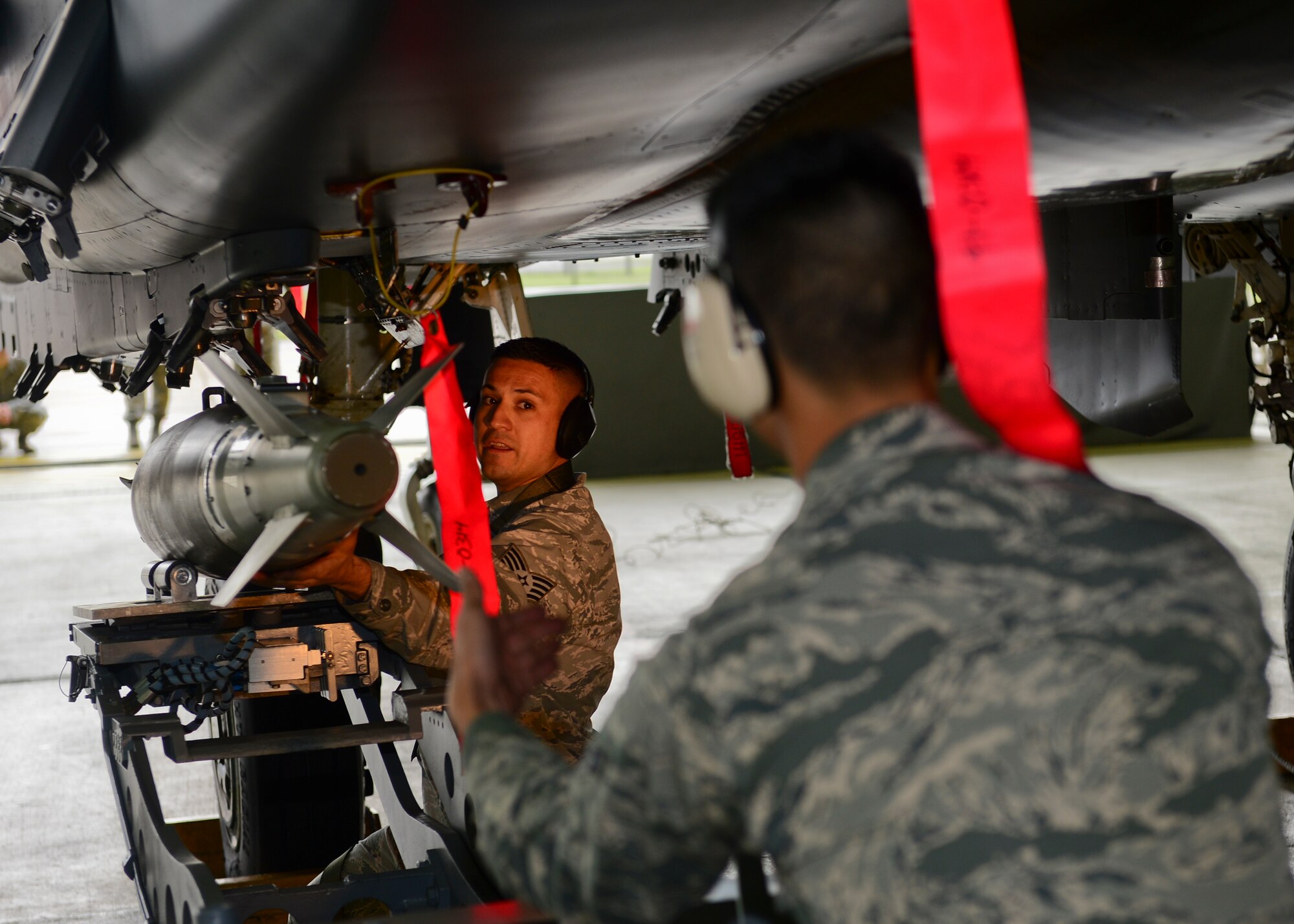 Staff Sgt. Jose Arellano, 494th Aircraft Maintenance Unit weapons team chief, secures a Guided Bomb Unit-31 to an F-15C Eagle during a load crew competition on Royal Air Force Lakenheath, England, Oct. 6, 2015. The four-part competition consisted of a written test, uniform inspection, a weapons load and an inspection of the composite toolkit to wrap things up. (U.S. Air Force photo by Senior Airman Nigel Sandridge/Released)