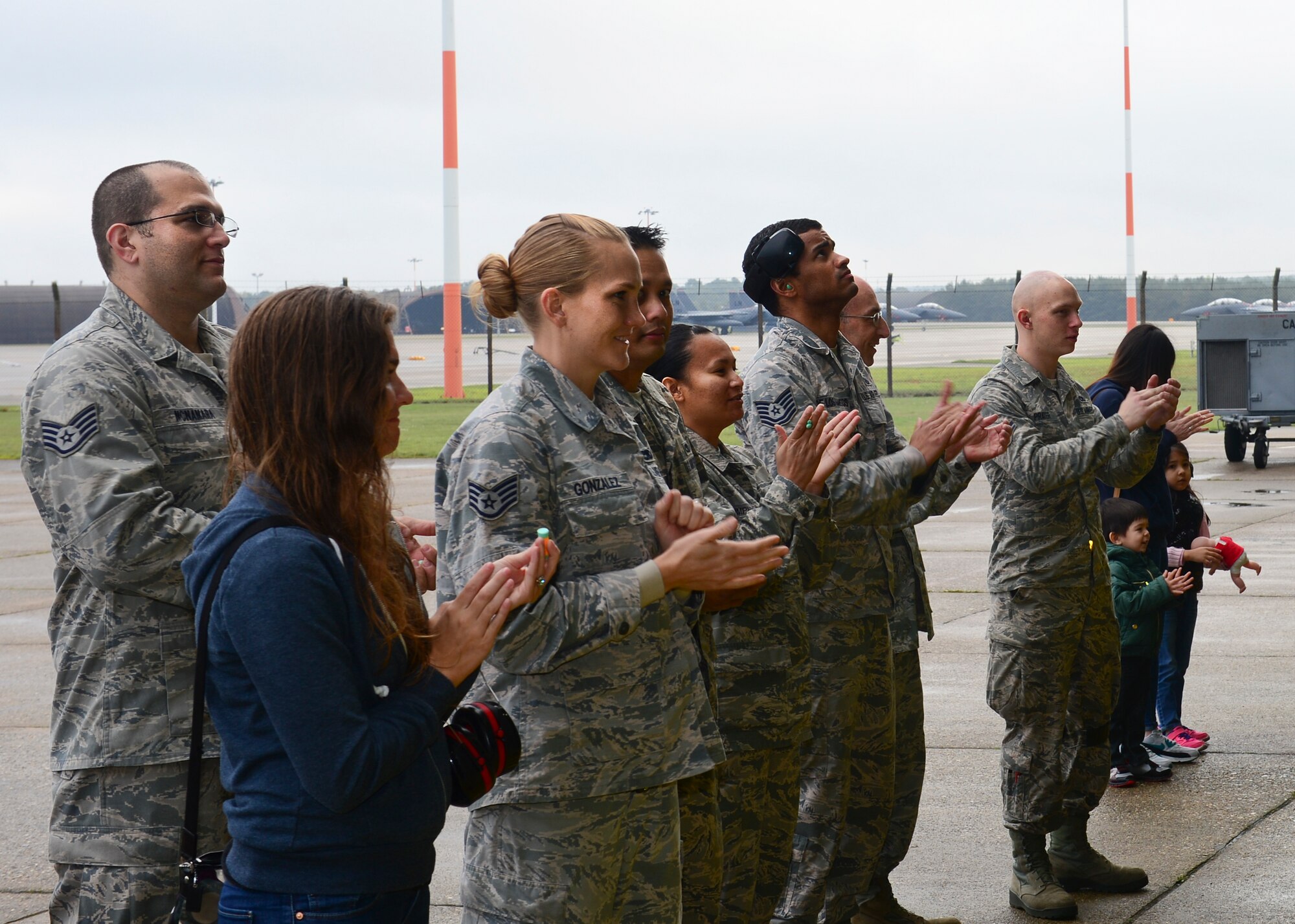 Squadron members and families cheer on Airmen during a load crew competition on Royal Air Force Lakenheath, England, Oct. 6, 2015. The four-part competition consisted of a written test, uniform inspection, a weapons load and an inspection of the composite toolkit to wrap things up. (U.S. Air Force photo by Senior Airman Nigel Sandridge/Released)