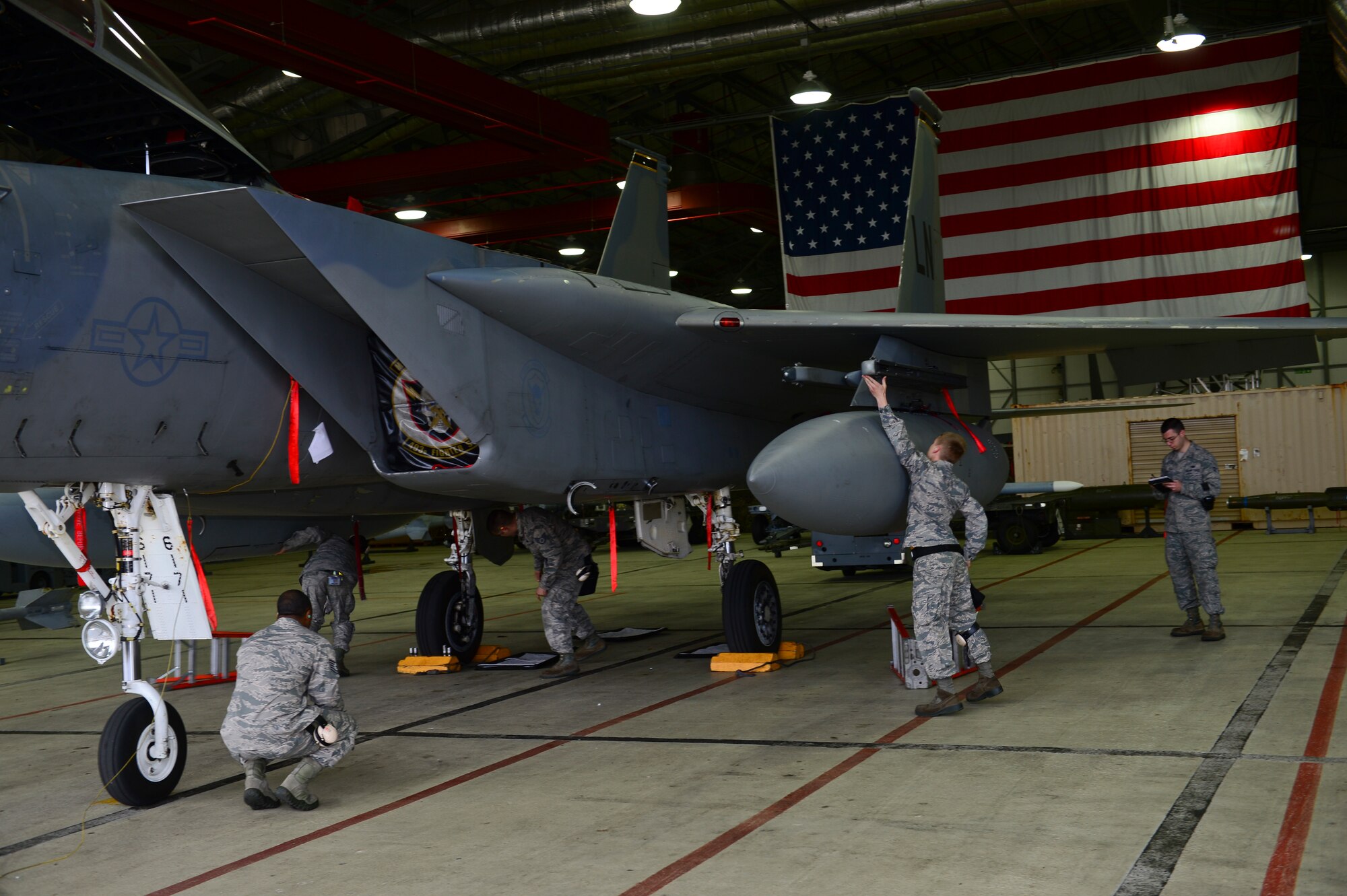 Weapons load crew members of the 493rd Aircraft Maintenance Unit work on an F-15C Eagle while inspectors observe during a load crew competition on Royal Air Force Lakenheath, England, Oct. 6, 2015. Airmen battled through the competition while being cheered on by their families and squadron members. (U.S. Air Force photo by Senior Airman Nigel Sandridge/Released)