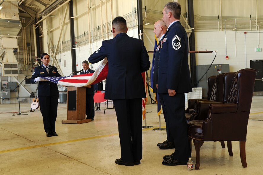 PETERSON AIR FORCE BASE, Colo. – Tech. Sgt. Courtney Ladue and Tech. Sgt. Jimmy Eitutis perform a flag folding ceremony at Chief Master Sgt. Gregory Weicher's retirement ceremony on Oct. 3, 2015 at Peterson AFB, Colo. Tech. Sgt. Ladue and Eitutis are both members of the 302nd Aeromedical Staging Squadron. (U.S. Air Force photo/Senior Airman Amber Sorsek)