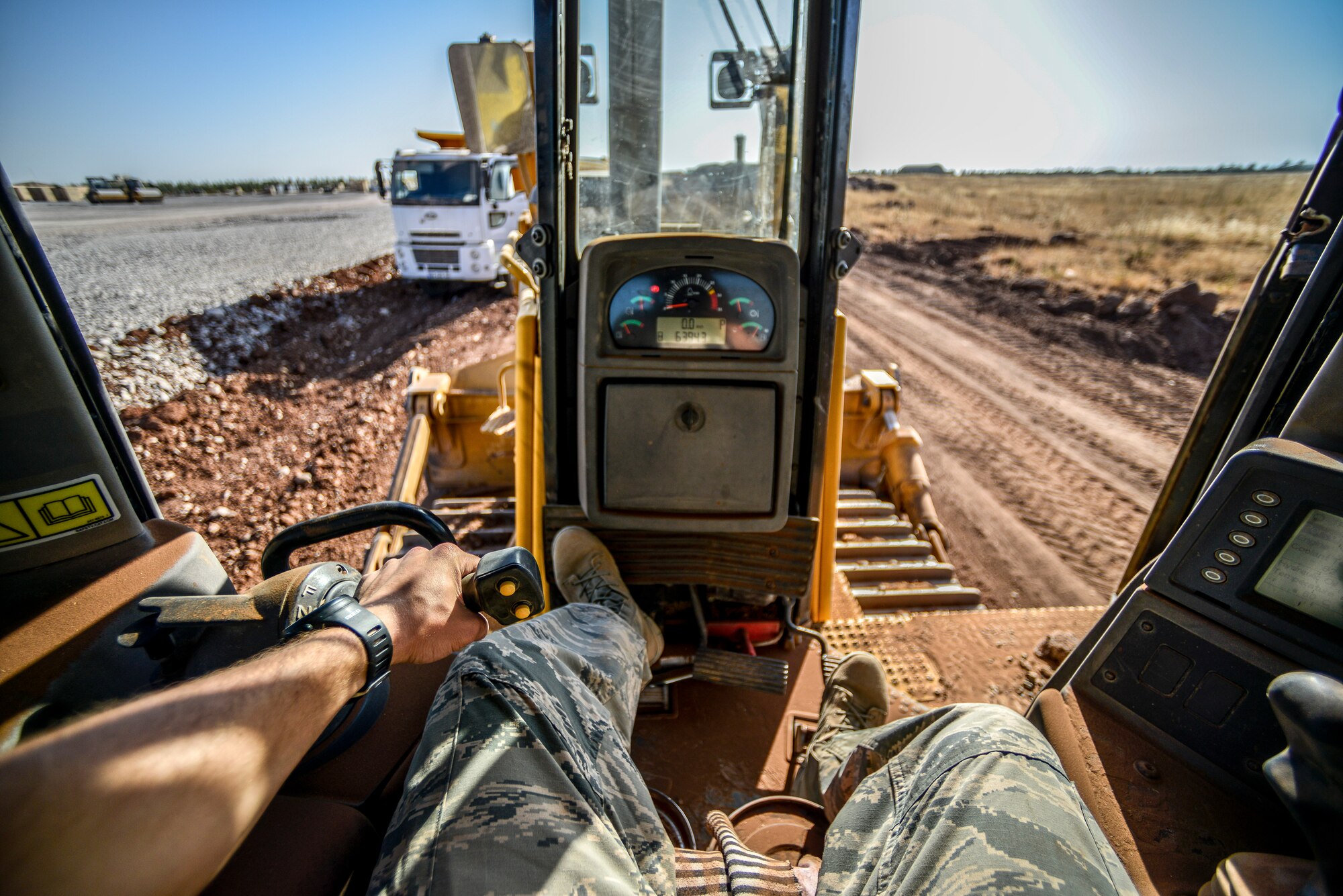 Staff Sgt. Logan Pals, 435th Construction Training Squadron pavements and construction equipment operator, sits in the seat of a bulldozer while waiting for gravel to be dumped Sept. 24, 2015, at Diyarbakir Air Base, Turkey. The ‘Dirt Boys’ have more than 10 construction vehicles that are used to dump, move, grade and roll gravel throughout base. (U.S. Air Force photo by Airman 1st Class Cory W. Bush/Released)