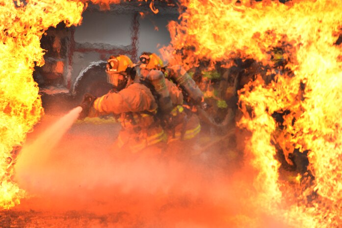 U.S. Air Force firefighters approach flames with a high pressure water hose at 165th Airlift Wing, Garden City, Ga., Oct. 3, 2015. The 165th AW firefighters train to meet both local, global protection needs, provide timely fire prevention education and protection to the wing, the Air Dominance Center and the airport tenants. (Air National Guard photo by Staff Sgt. Noel Velez/Released)