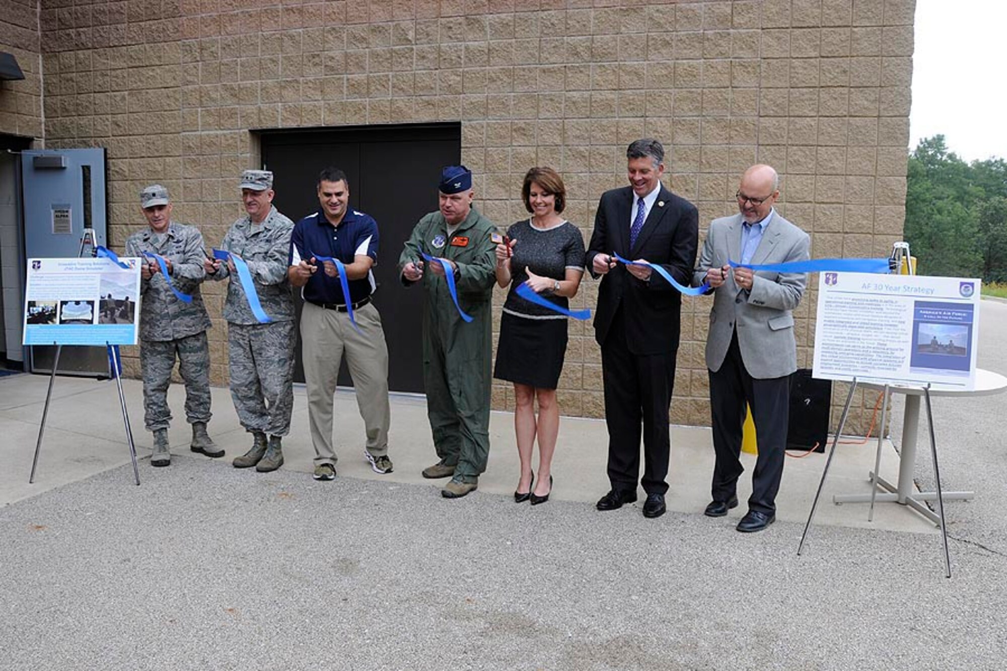 From left, U.S. Air Force Lt. Col. Brian S. Filler, 182nd Air Support Operations Group commander; Maj. Gen. William D. Cobetto, Illinois Assistant Adjutant General – Air; state Rep. Michael Unes, R-East Peoria; Col. William P. Robertson, 182nd Airlift Wing commander; U.S. Rep. Cheri Bustos, D-Ill.; U.S. Rep. Darin LaHood, R-Ill.; and state Sen. David Koehler, D-Peoria, perform a ribbon cutting for the Air National Guard Advanced Joint Terminal Attack Controller Training System at the 182nd Airlift Wing in Peoria, Ill., Oct. 5, 2015. Battlefield Airmen with Peoria’s 169th Air Support Operations Squadron, Illinois Air National Guard, teamed up with the QuantaDyn Corporation to help create the AAJTS, which is expected to potentially save the government $95 million through fiscal year 2018 by reducing the cost of qualification and continuation training by 48 percent. (U.S. Air National Guard photo by Tech. Sgt. Todd A. Pendleton/Released)