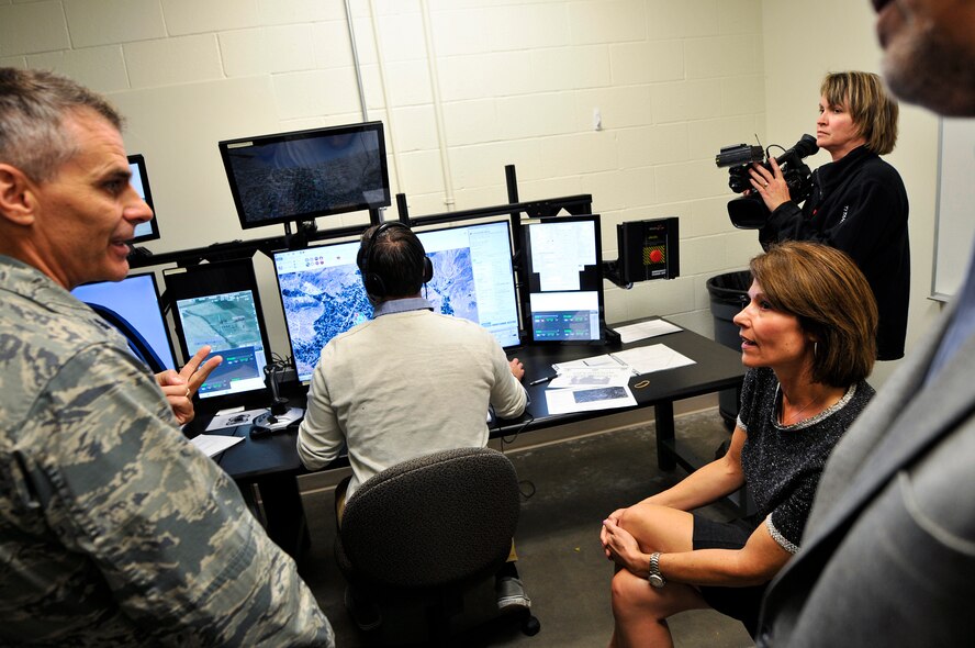 U.S. Air Force Lt. Col. Brian S. Filler, left, commander of the 182nd Air Support Operations Group, Illinois Air National Guard, explains to U.S. Rep. Cheri Bustos, D-Ill., sitting, how the Air National Guard Advanced Joint Terminal Attack Controller Training System works after a ribbon cutting ceremony at the 182nd Airlift Wing in Peoria, Ill., Oct. 5, 2015. Peoria’s 169th Air Support Operations Squadron TACPs teamed up with the QuantaDyn Corporation to help create the AAJTS, which is expected to potentially save the government $95 million through fiscal year 2018 by reducing the cost of qualification and continuation training by 48 percent. (U.S. Air National Guard photo by Staff Sgt. Lealan Buehrer/Released)