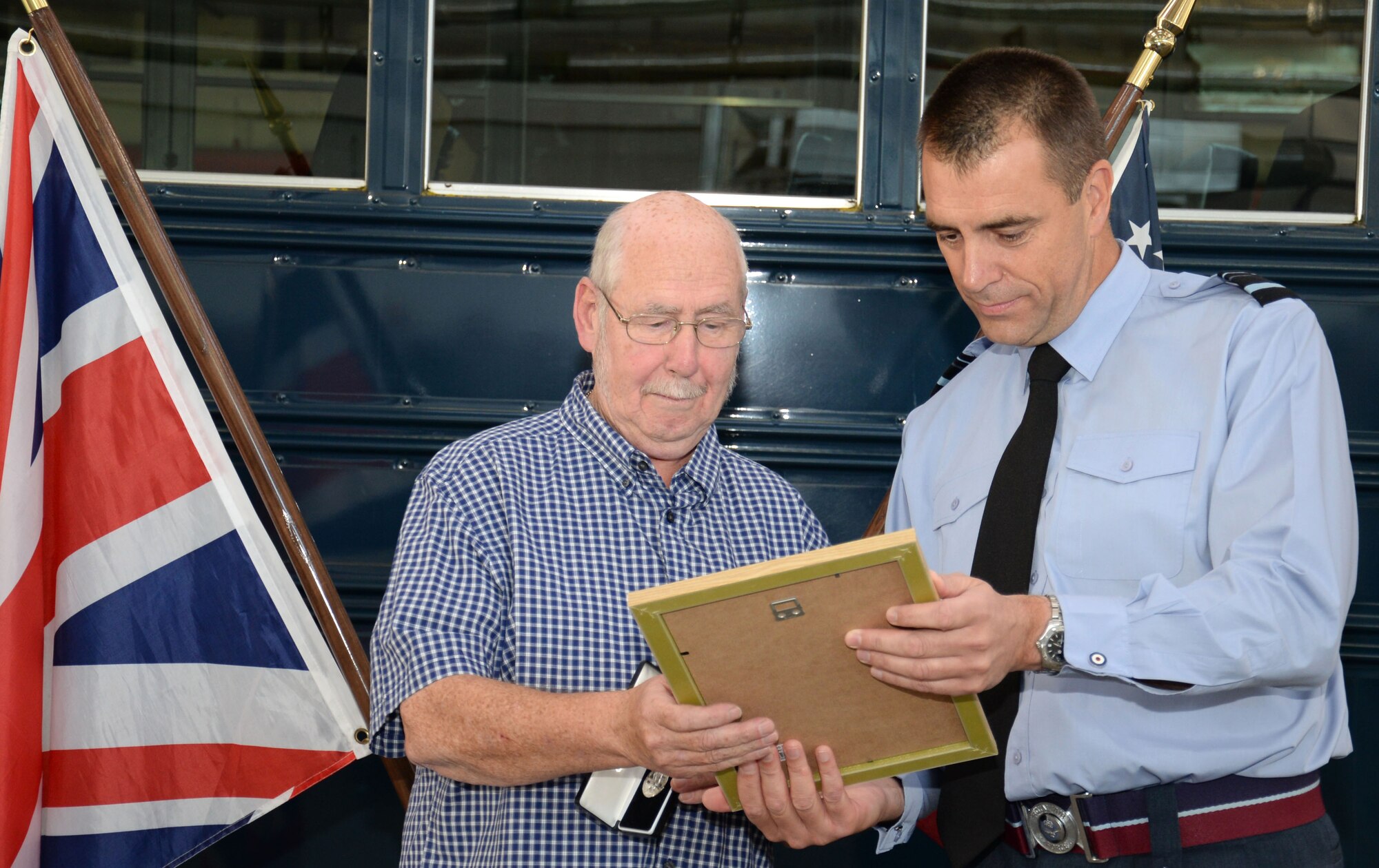 Air Vice Marshal Tim Bishop, right, Air Officer Commanding 38 Group, presents John Lake, retired Ministry of Defence vehicle operator, with the Imperial Service Medal on behalf of Her Majesty The Queen following 32 years of service Oct. 1, 2015, at RAF Mildenhall, England. Over the years Lake supported seven real-world major contingency operations from operations in Kuwait and Iraq from 1990 to 1991, and in Afghanistan from 2001 to 2014. (U.S. Air Force photo by Gina Randall/Released)