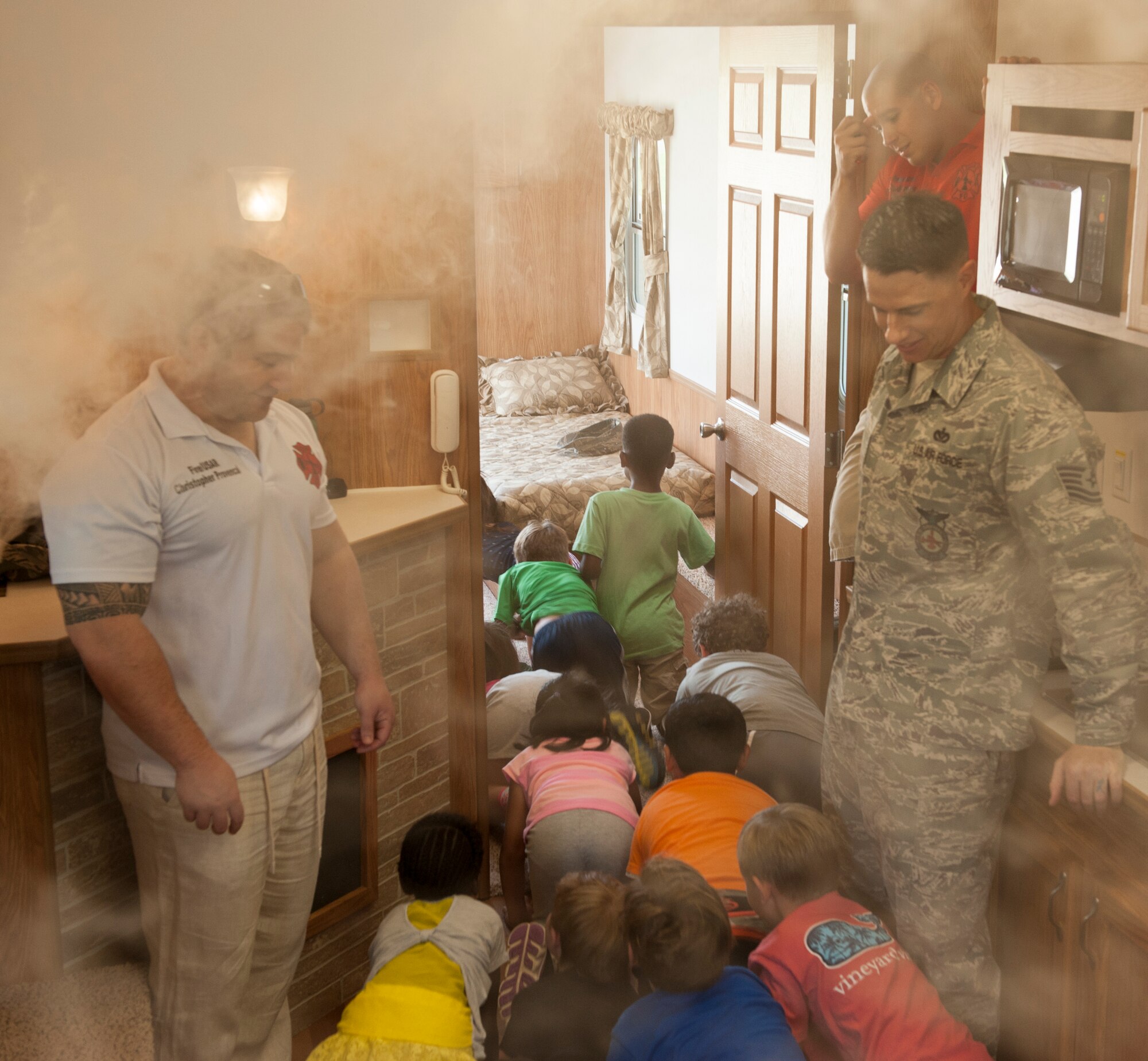 U.S. Air Force firefighters from the 18th Civil Engineer Squadron, Tech. Sgt. Christopher Provencal and Tech. Sgt. Joseph Price, instruct Kadena Elementary School children on what to do in the event of a fire Oct. 7, 2015, on Kadena Air Base, Japan. A demonstration was held to inform children about the importance of testing smoke alarms as part of Fire Prevention Week. This year’s theme is “hear the beep where you sleep”. (U.S. Air Force photo by Airman 1st Class Corey M. Pettis)