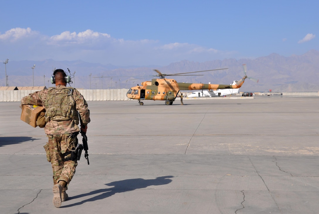 U.S. Air Force Tech. Sgt. Angel Gonzalez, C-130 maintenance supply liaison at Train, Advise, Assist Command - Air makes his way to an Afghan air force Mi-17 helicopter at Bagram Air Field, Afghanistan, Oct. 5, 2015. Gonzalez flies from Kabul to Bagram multiple times a week to cut roughly 10 days off the shipping process for C-130 parts needed to maintain and sustain the Afghan air force’s C-130 Hercules aircraft flying in support of Afghan army operations across the country. U.S. Air Force photo by Capt. Edith Sakura