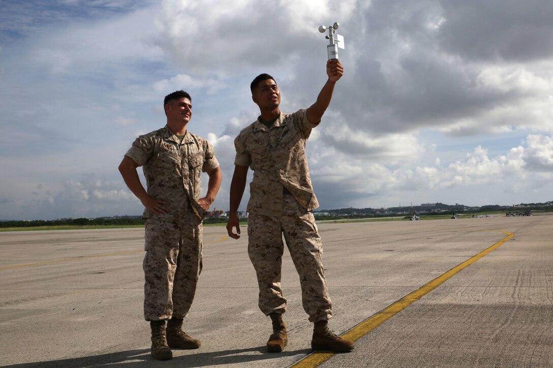 Lance Cpl. Jacob Milbauer, left, and Lance Cpl. Somart Pil use an anemometer to record current weather conditions Aug. 31 on Marine Corps Air Station Futenma. Keeping pilots informed of the current weather condition contributes to the overall safety within Headquarters and Headquarters Squadron, MCAS Futenma, Marine Corps Installations Pacific-Marine Corps Base Camp Butler, Japan, which reached 100,000 flight hours without incident Oct. 1. Pil and Milbauer are meteorology and oceanography specialists with Air Traffic Control, Marine Air Control Squadron 4, Marine Air Control Group 18, 1st Marine Aircraft Wing, III Marine Expeditionary Force.