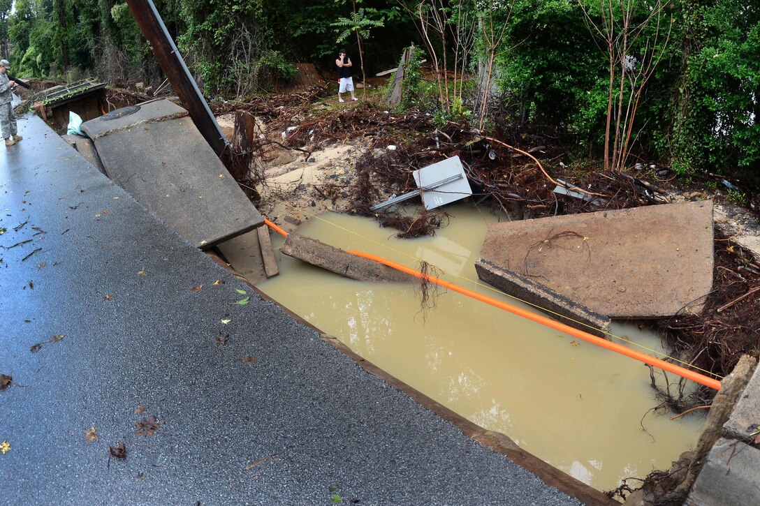 A soldier and civilian observe and report the massive devastation caused by heavy rainfall at the intersection of Beltline Boulevard and East Buchanan Drive in Columbia, S.C., Oct. 5, 2015. South Carolina Air National Guard photo by Airman 1st Class Ashleigh S. Pavelek