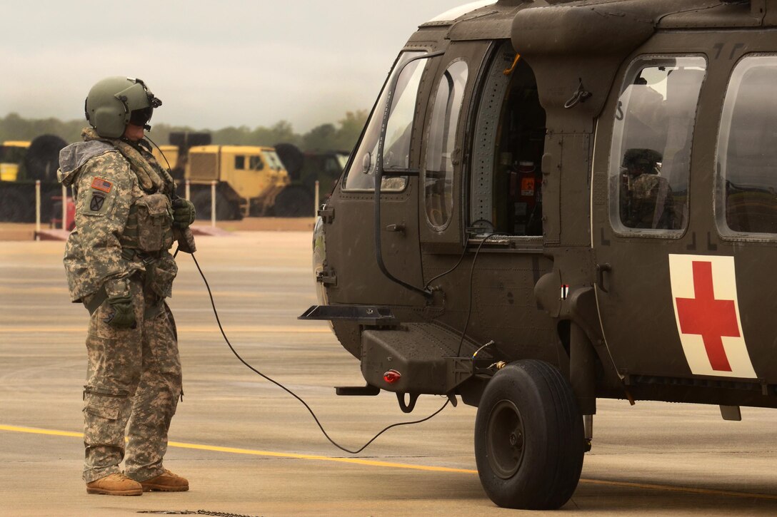 A soldier prepares his UH-60 Black Hawk helicopter before conducting rescue and support operations during a statewide flood response from the South Carolina National Guard’s Army Aviation Support Facility on McEntire Joint National Guard Base, S.C., Oct. 5, 2015. South Carolina Air National Guard photo by Senior Master Sgt. Edward Snyder