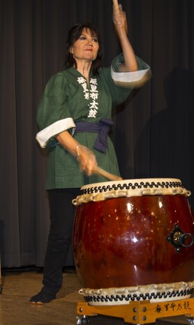 Dr. Suzanne Landrum, principal of Matthew C. Perry Elementary School, plays the drums with a local drum group, “Marifu Daiko”, during the Info Expo inside the Club Iwakuni Grand Ballroom aboard Marine Corps Air Station Iwakuni, Japan, Sept. 12, 2015. The group includes station residents and local Japanese drummers. The Info Expo provided an opportunity for station residents to familiarize themselves with services offered on and off base as well as travel, shopping, and cultural experiences available.
